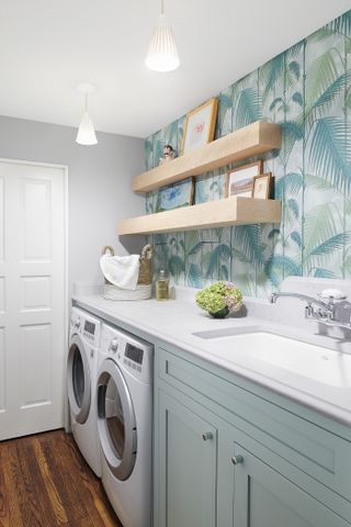 Laundry room with palm print wallpaper and open shelving