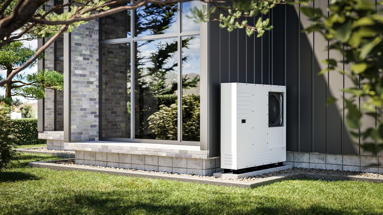 Heat pump installed at the wall of a modern single-family house