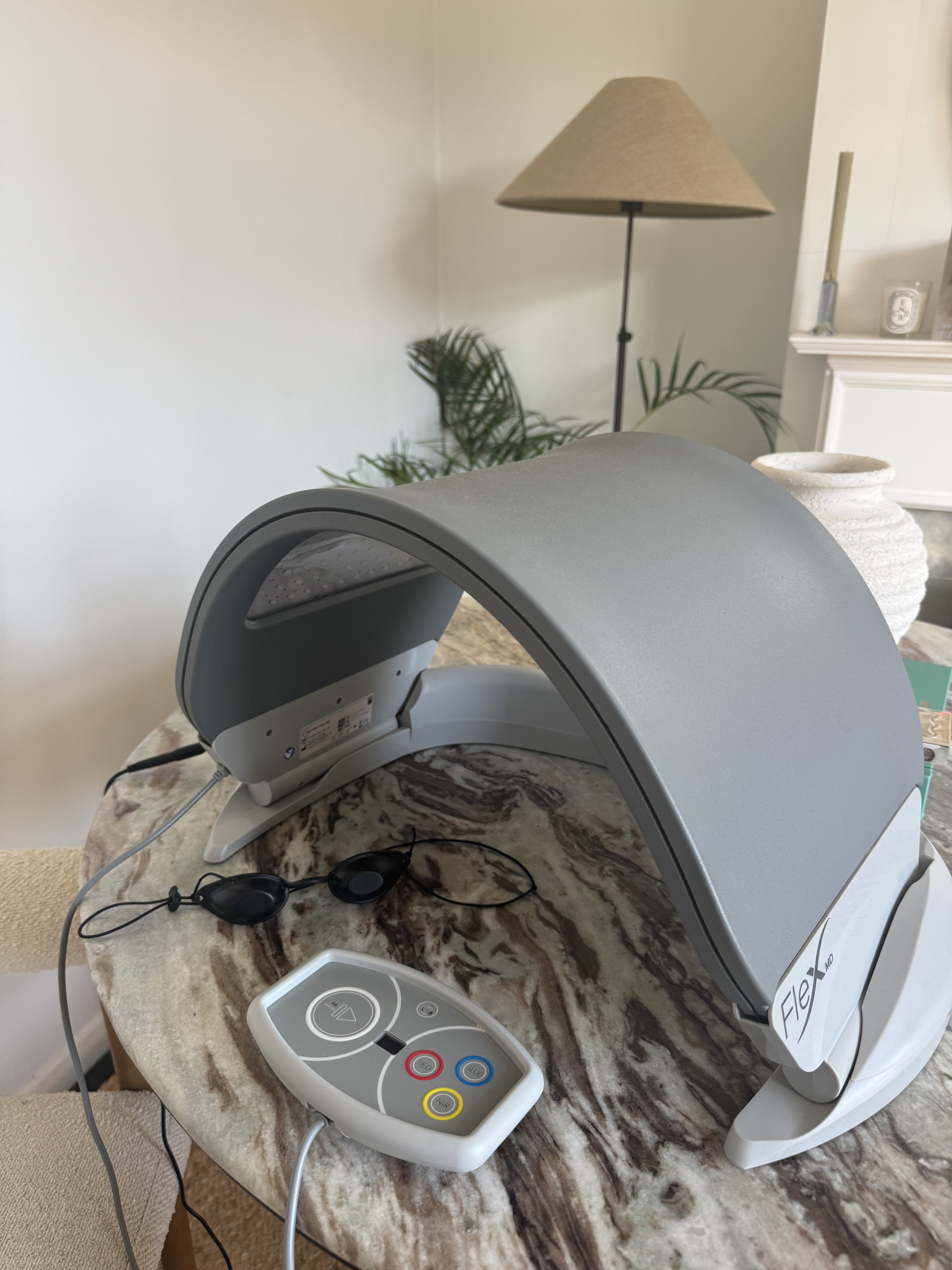 The Dermalux MD LED panel and base switched off, with the remote and goggles