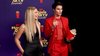 LOS ANGELES, CALIFORNIA - MAY 16: (L-R) Madelyn Cline and Chase Stokes, winners of the Best Kiss award for 'Outer Banks,' pose with a golden popcorn statuette backstage during the 2021 MTV Movie & TV Awards at the Hollywood Palladium on May 16, 2021 in Los Angeles, California.