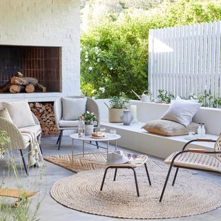 outdoor sitting area with white sofa and armchairs