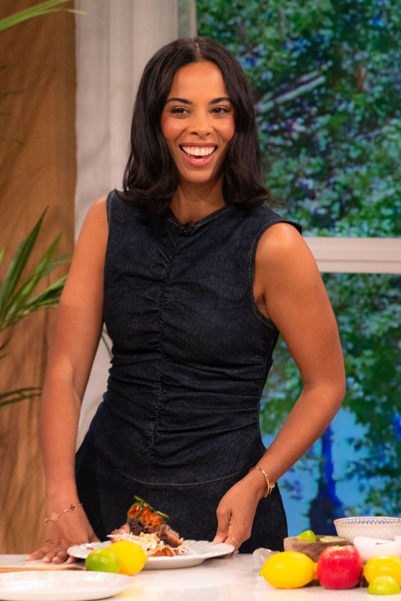 Rochelle Humes on This Morning in a denim dress with ruched detail standing at the kitchen counter with a plate of food