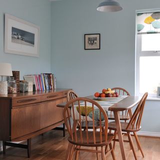 dining room with sky blue wall and dining table with wooden chairs