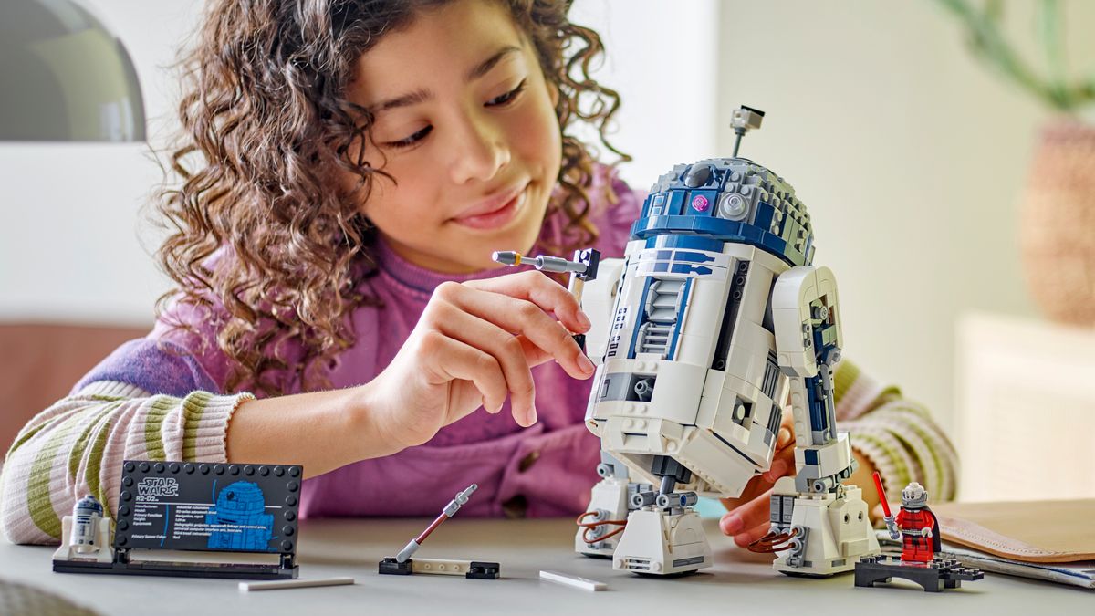 A child plays with the Lego R2-D2 kit at the table