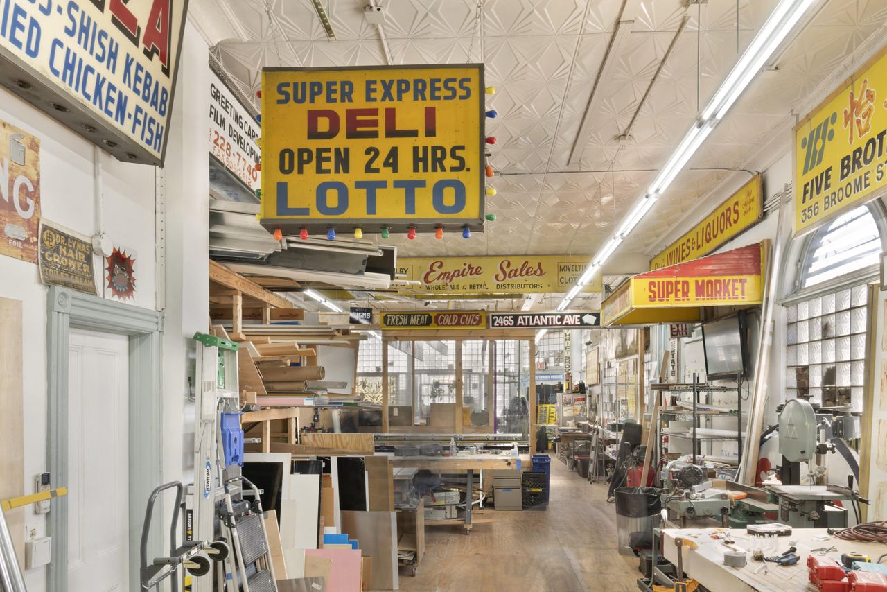 A crafts workshop with vintage signs and filled with equipment.