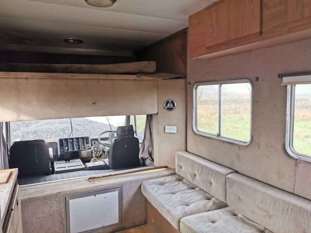The inside of the caravan shows white dirty seats