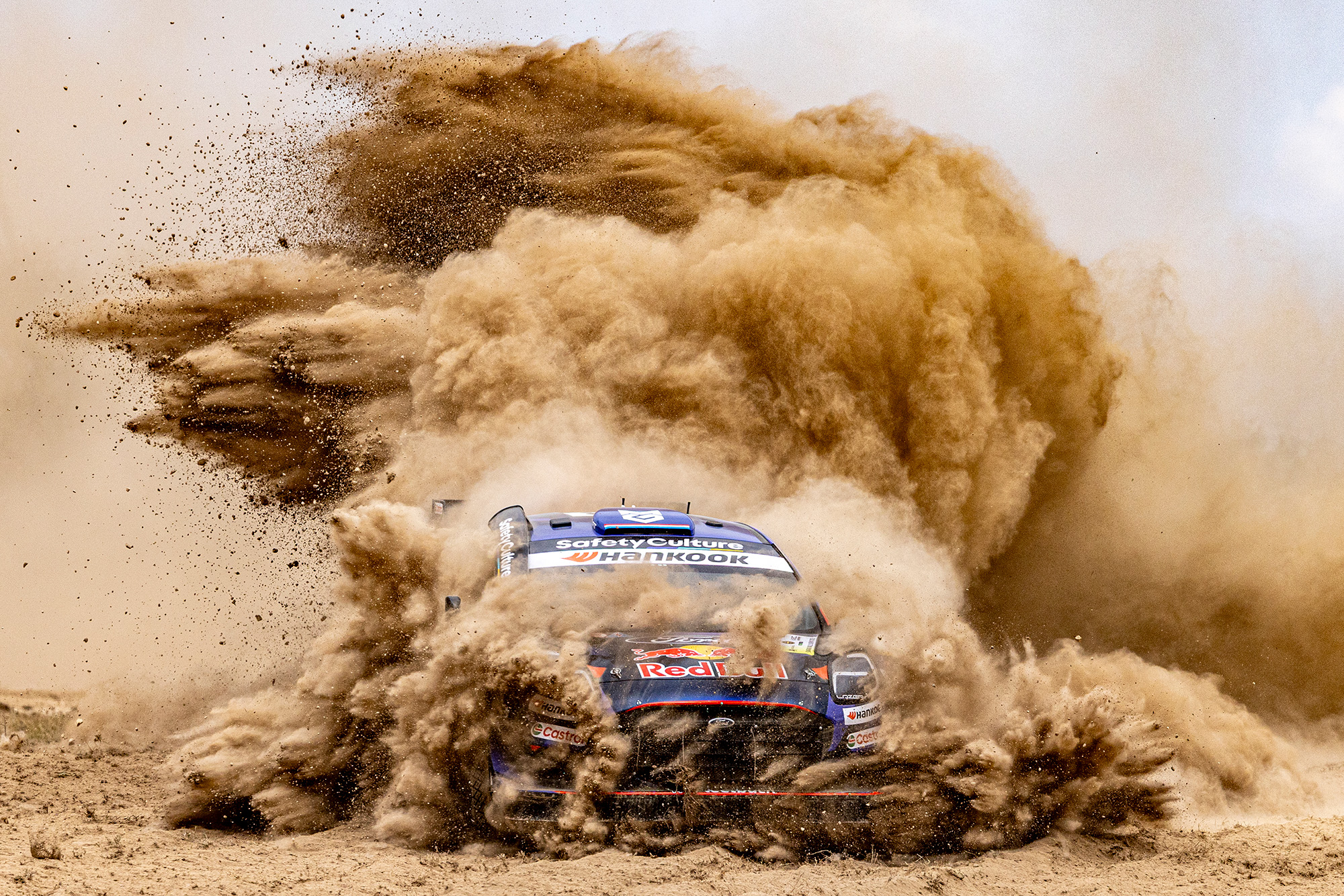 WRC rally car surrounded by dust plume