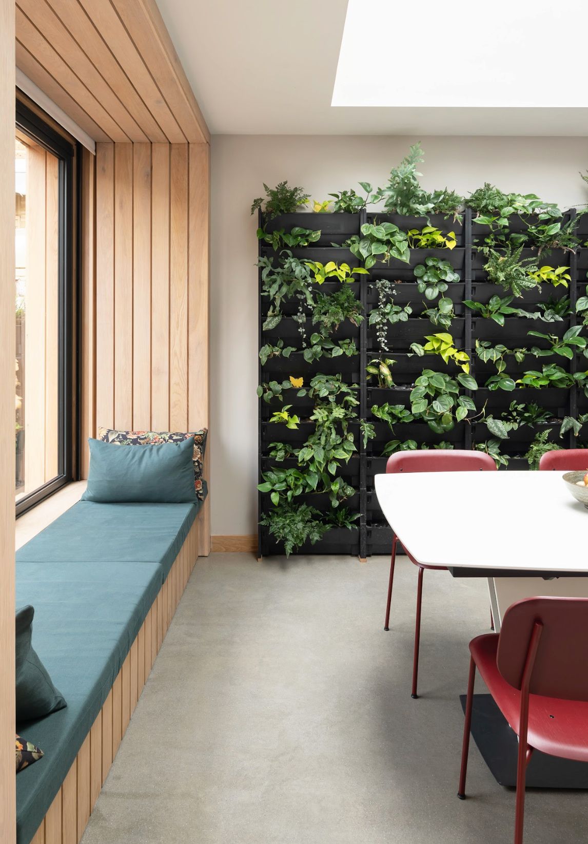 A kitchen with a green living wall and a window seat