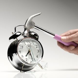 Smashing alarm clock with hammer