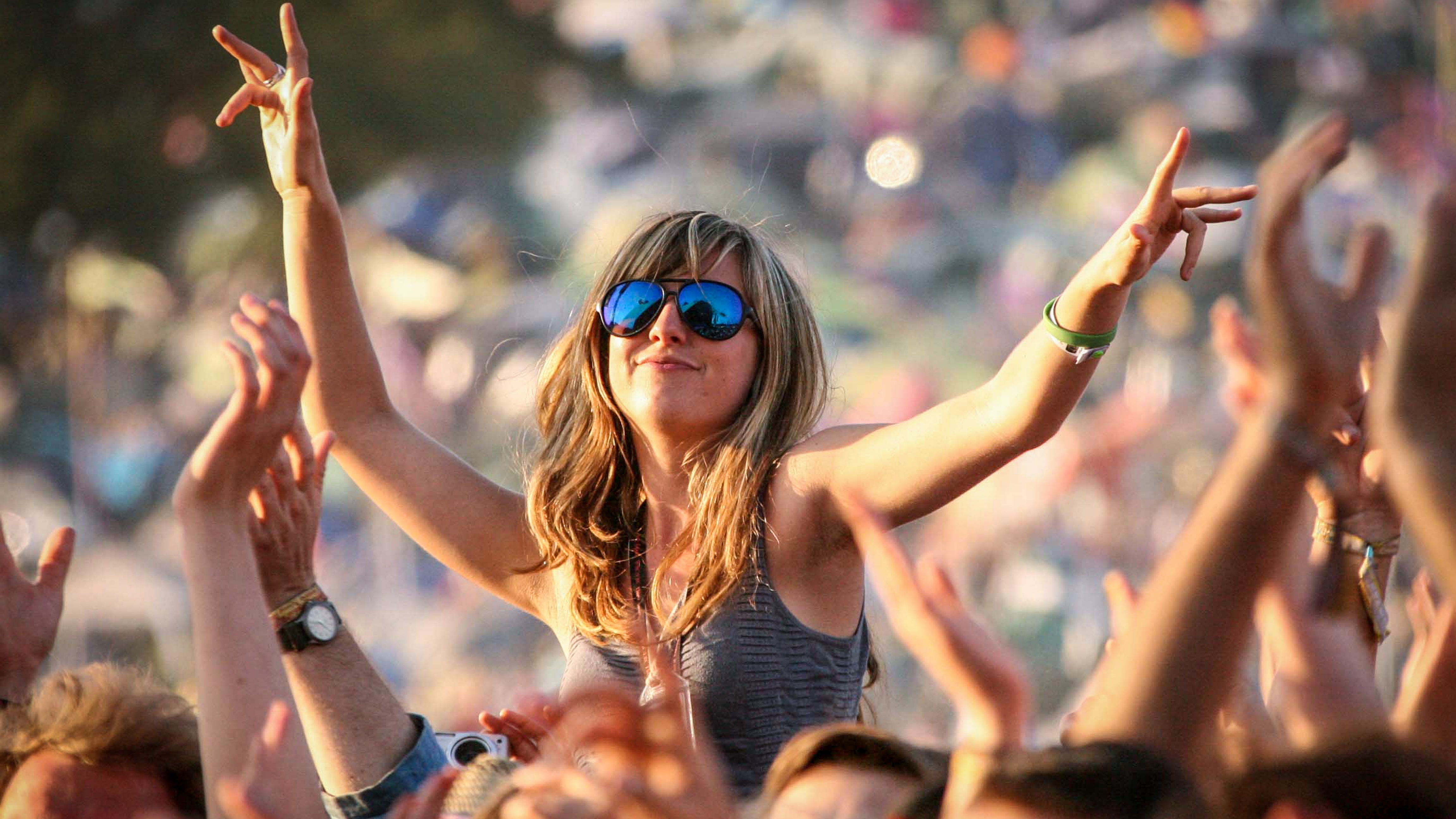 A woman dances on a friend&#039;s shoulders at the Glastonbury Festival held at Worthy Farm, in Pilton, Somerset on June 29 near Glastonbury, England. The festival, founded in 1970, has grown into one of the largest outdoor green field festivals in the world.(Photo by Matt Cardy/Getty Images)
