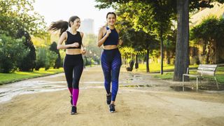 two women running in a park, laughing and chatting