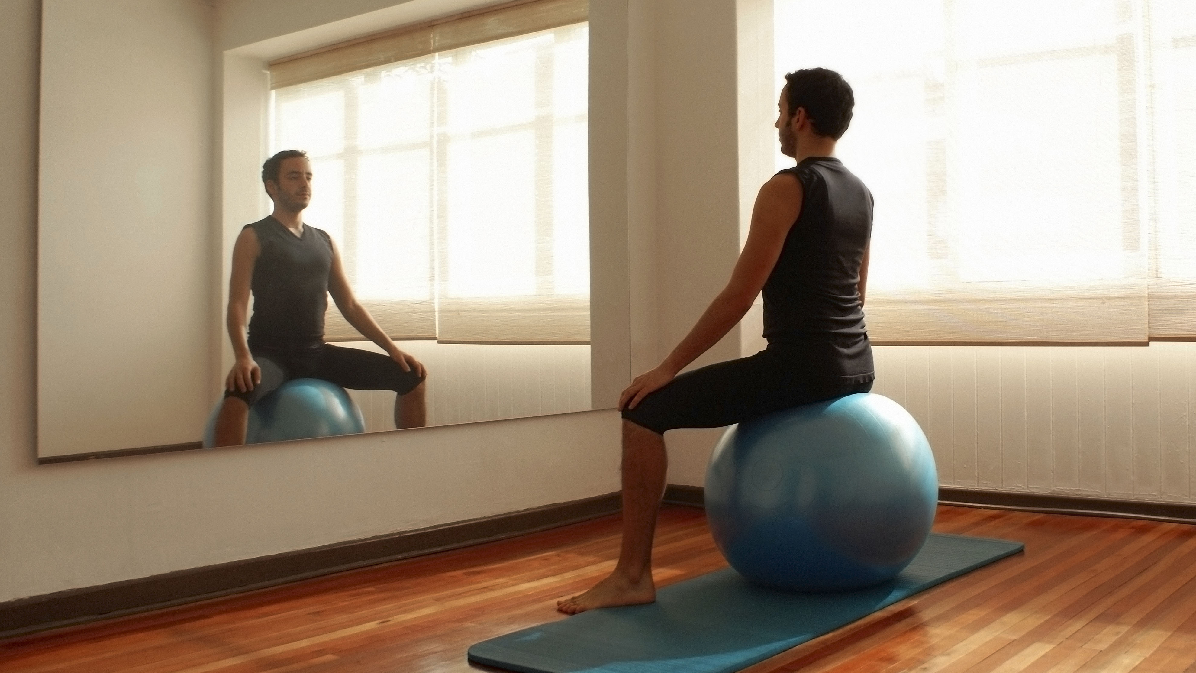 Man doing one of the best ab exercises, swiss ball sits, in home gym