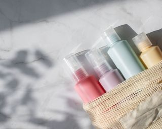 Travel toiletries in a hessian bag on marble countertop