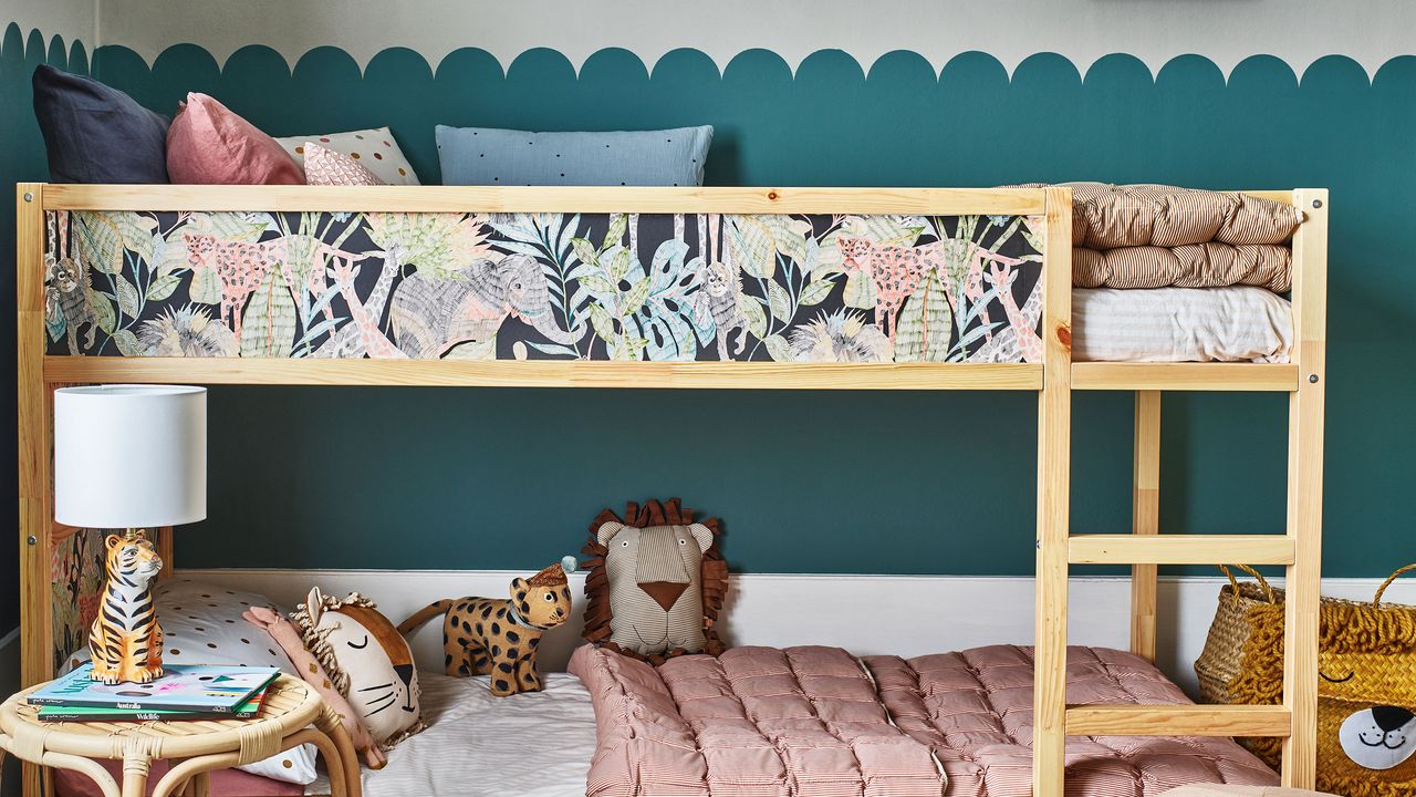 Kids bedroom with bunk bed decorated with wallpaper and scalloped decorated wall behind