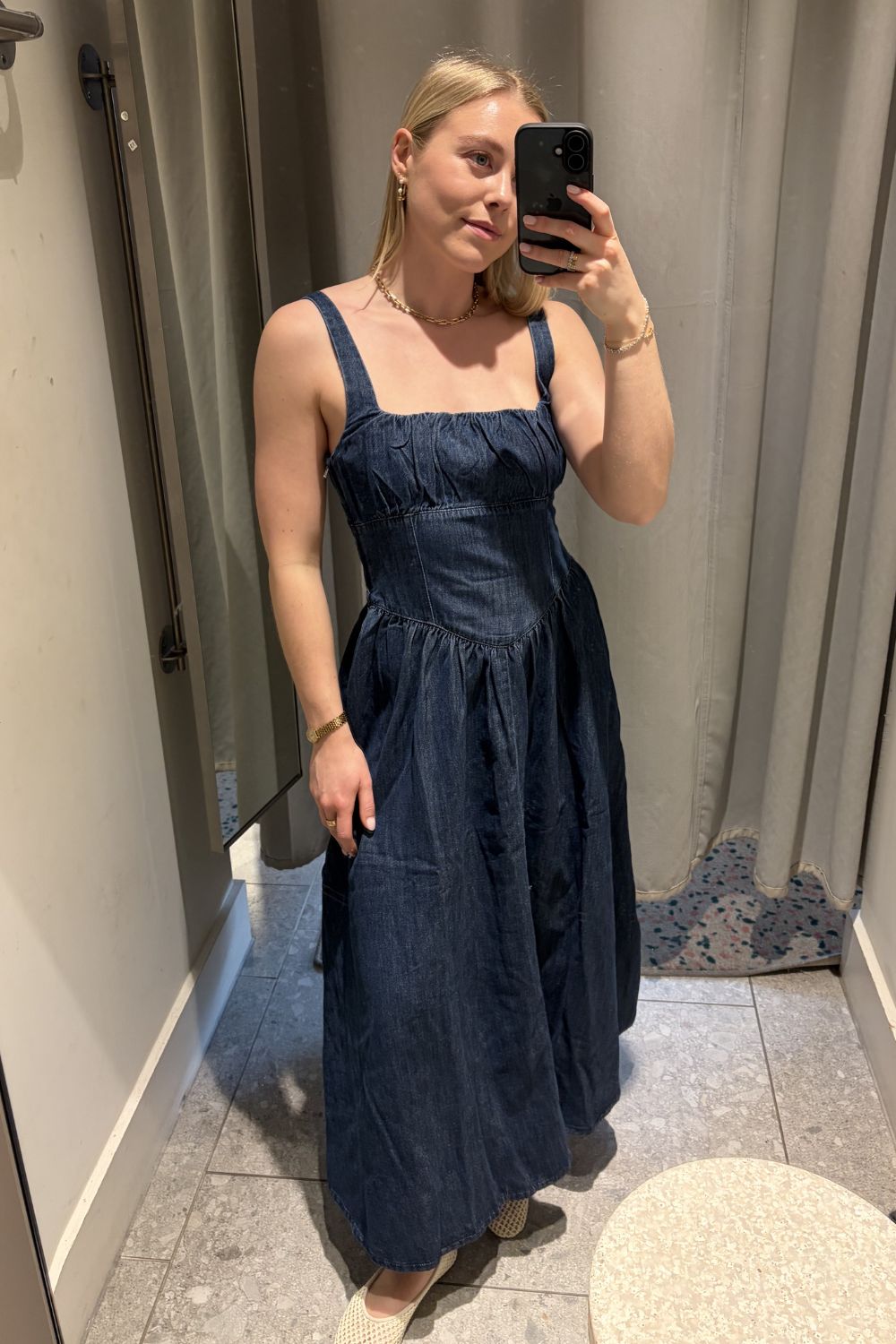 Woman wears denim dress and woven ballet flats