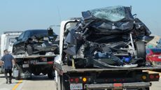 A Tesla and a Honda Civic sit on tow trucks following an accident in Seal Beach, California.