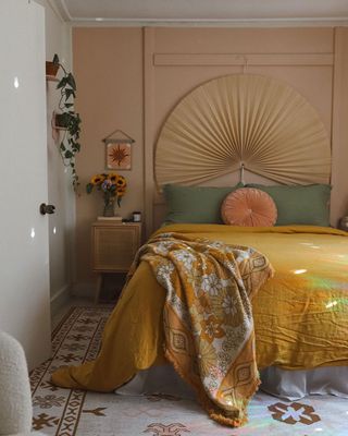 Cozy boho bedroom with apricot walls, soft bed linen and cushion covers