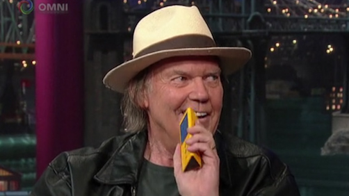 Neil Young holding a Pono player