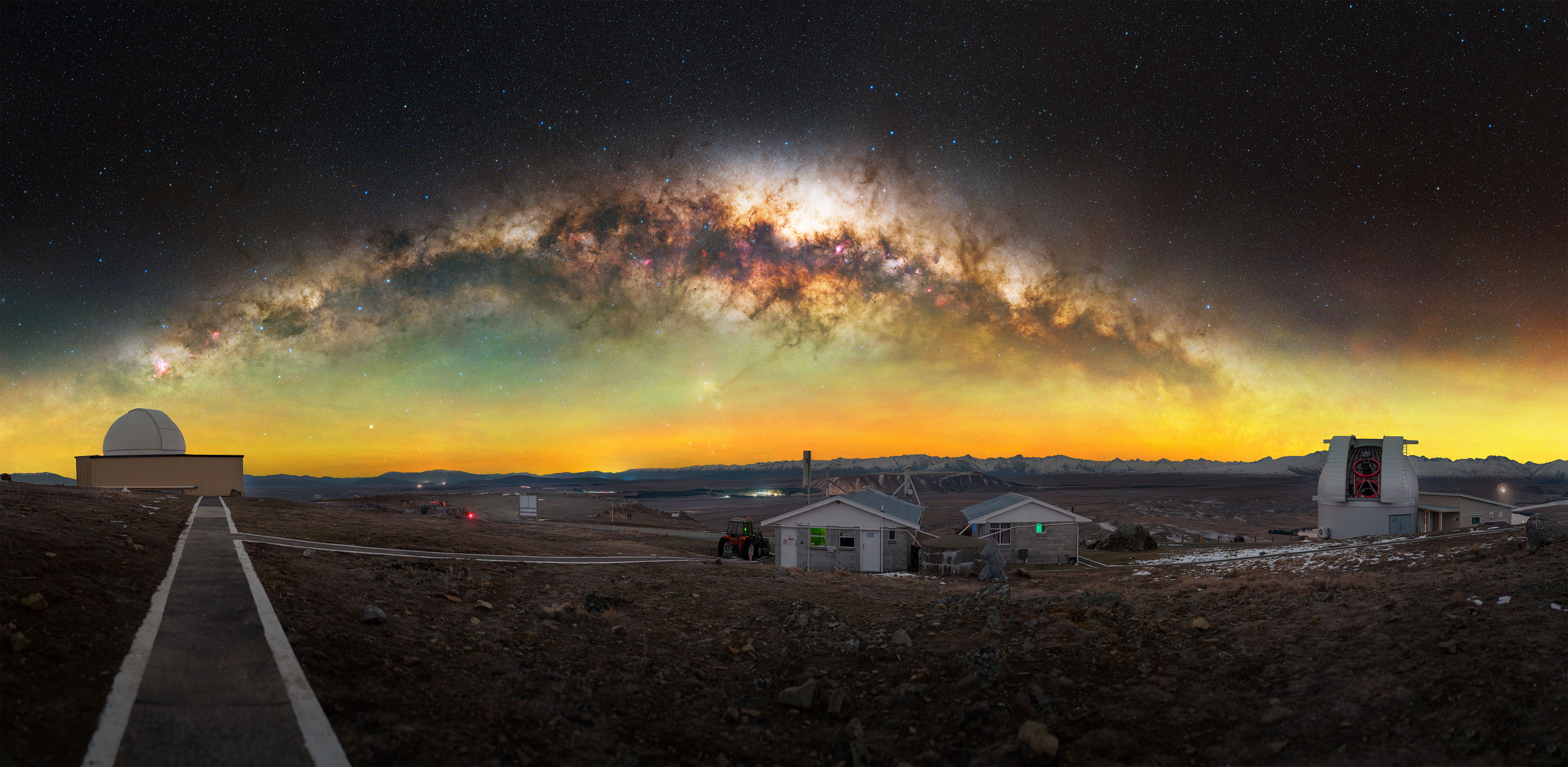 The Milky Way is seen in the night sky with yellow around the galaxy over a city