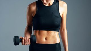 a photo of a woman holding a dumbbell with abs