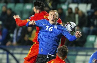 Kieffer Moore, left, fights for the ball with Estonia’s Joonas Tamm