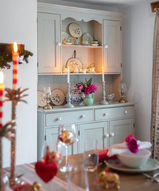 dresser and dining table decorated for christmas with subtle candlelight and simple decorations