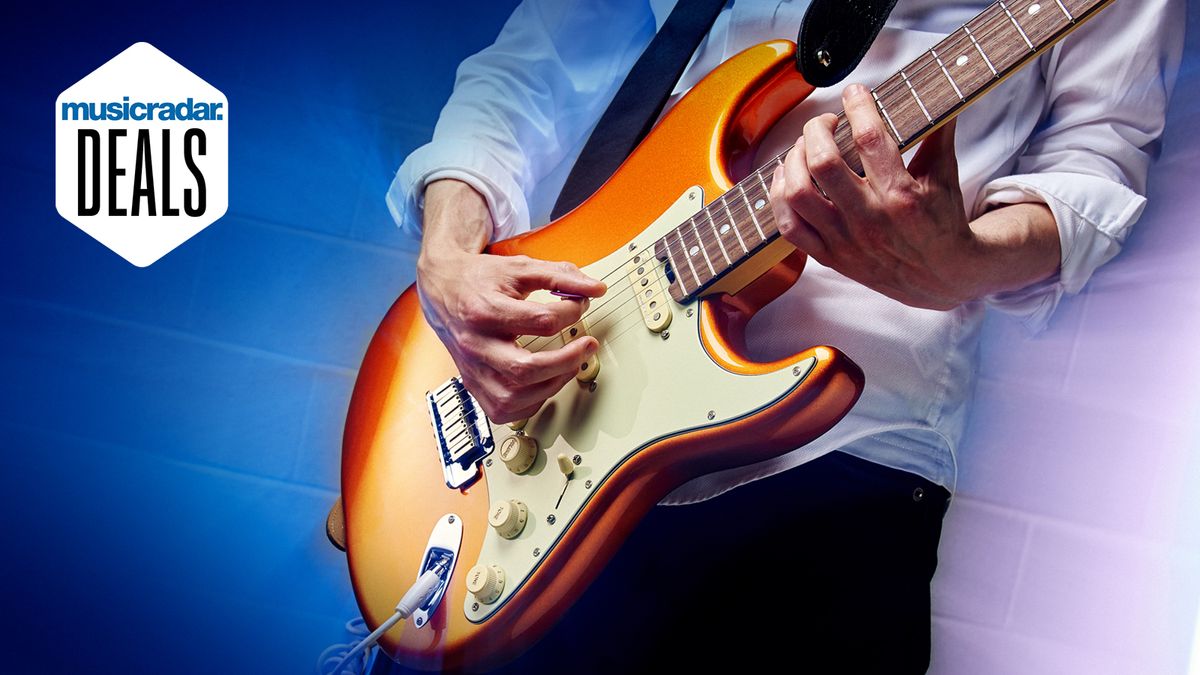 Man plays orange Stratocaster guitar