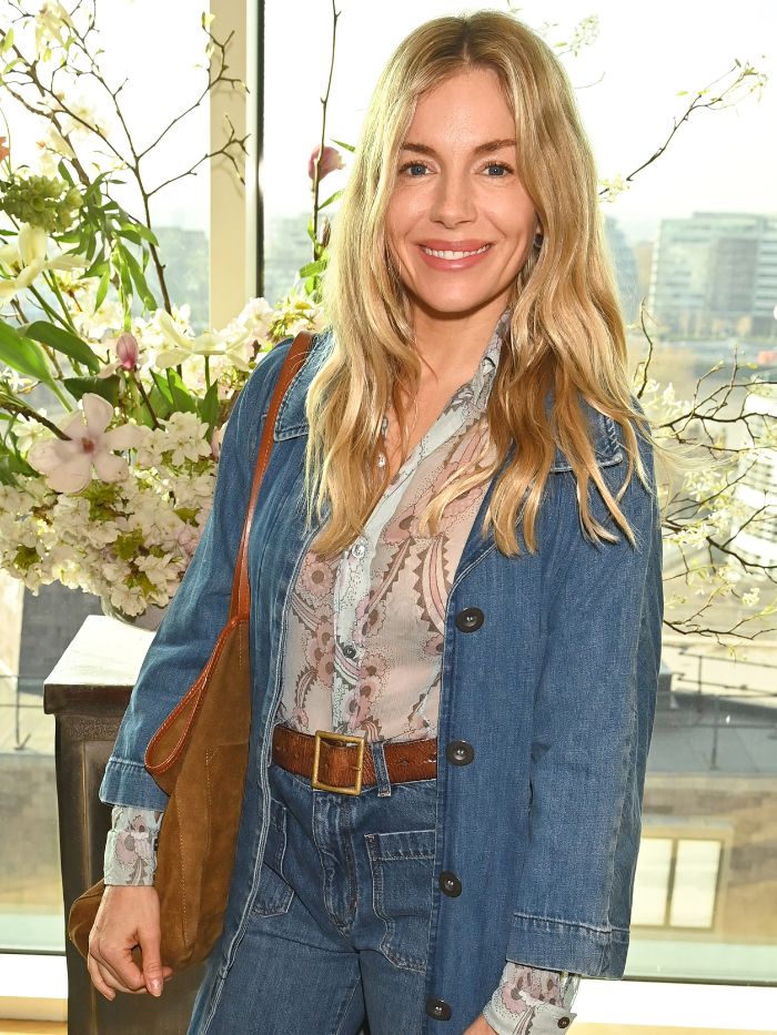 Sienna Miller wearing a floral blouse and denim jacket at an event