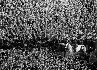 PC George Storey, on his horse Billie, helps clear crowds from the pitch ahead of the 1923 FA Cup final between Bolton Wanderers and West Ham United at Wembley Stadium