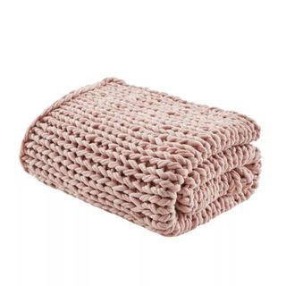 A folded light pink knitted blanket