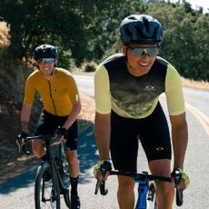 Two cyclists wearing Oakley cycling gear and eyeglasses. 
