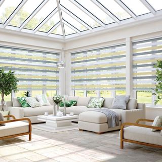 A spacious conservatory with yellow and grey striped blinds
