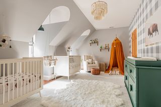 gender neutral nursery with twin cots, orange canopy area, green chest of drawers, fluffy rug, loft space