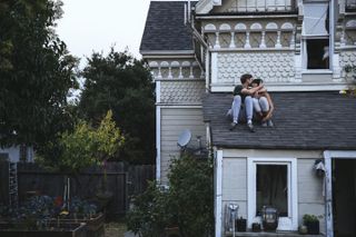Sex dream meaning: A couple sit on a roof kissing