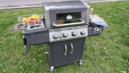 The Cuisinart Four Burner Dual Fuel Gas Grill outside ready to cook food
