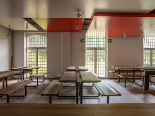 Tables with benches in restaurant interior with red ceiling panels