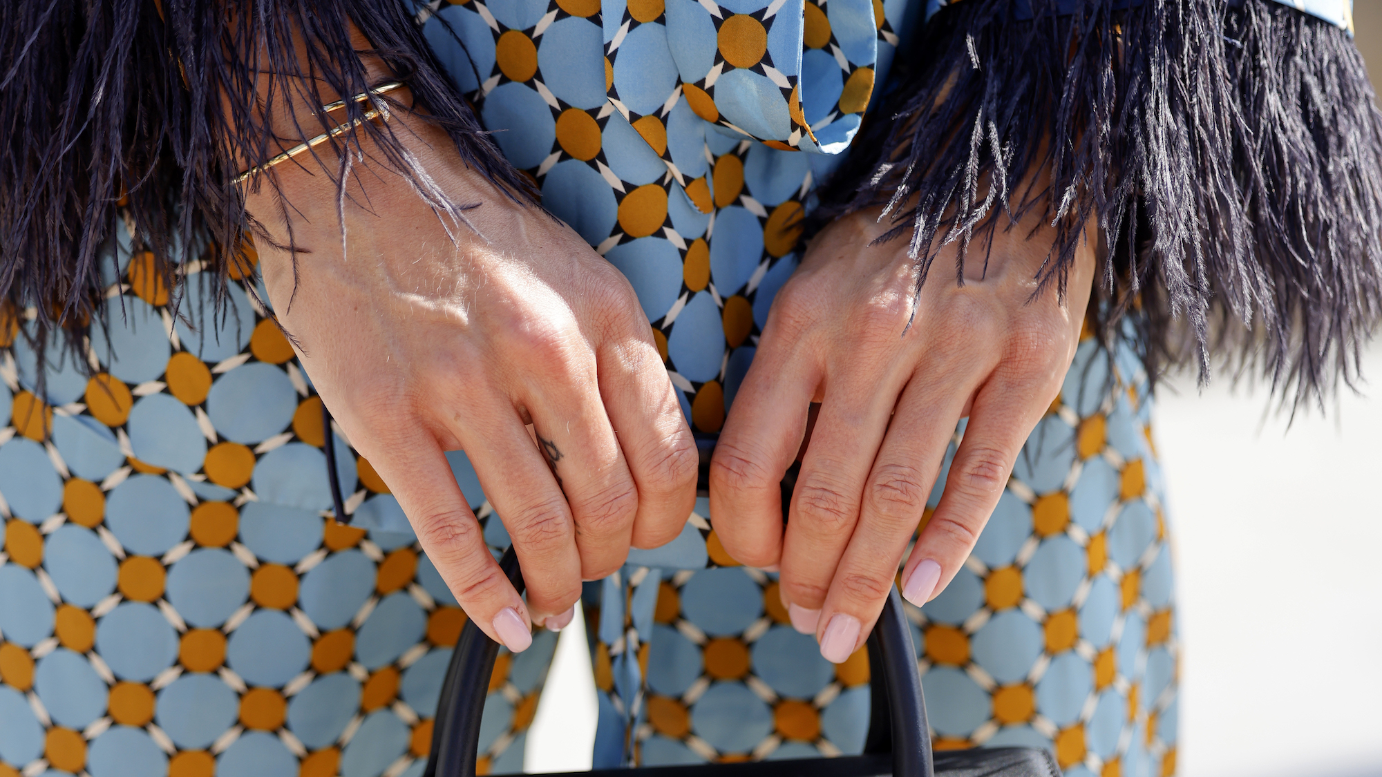woman with strawberry jell-o nails and blue patterned suit