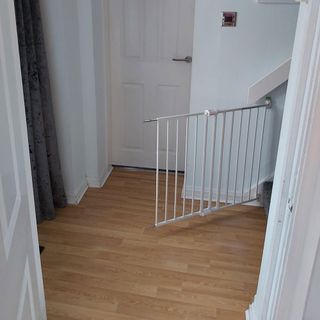 hallway with white wall and wooden flooring