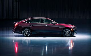 Cadillac CT5 in deep red, photographed in a garage with a spotlight on it.