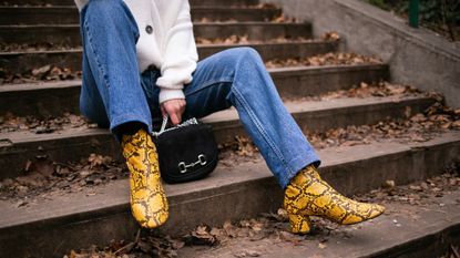 woman sitting on steps wearing yellow patterned boots
