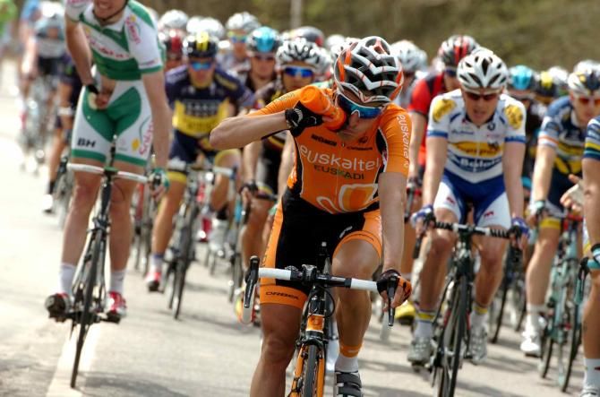 Igor Anton (Euskaltel Euskadi) takes a drink while another takes relief from too much