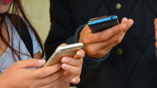 Two people texting on smartphones