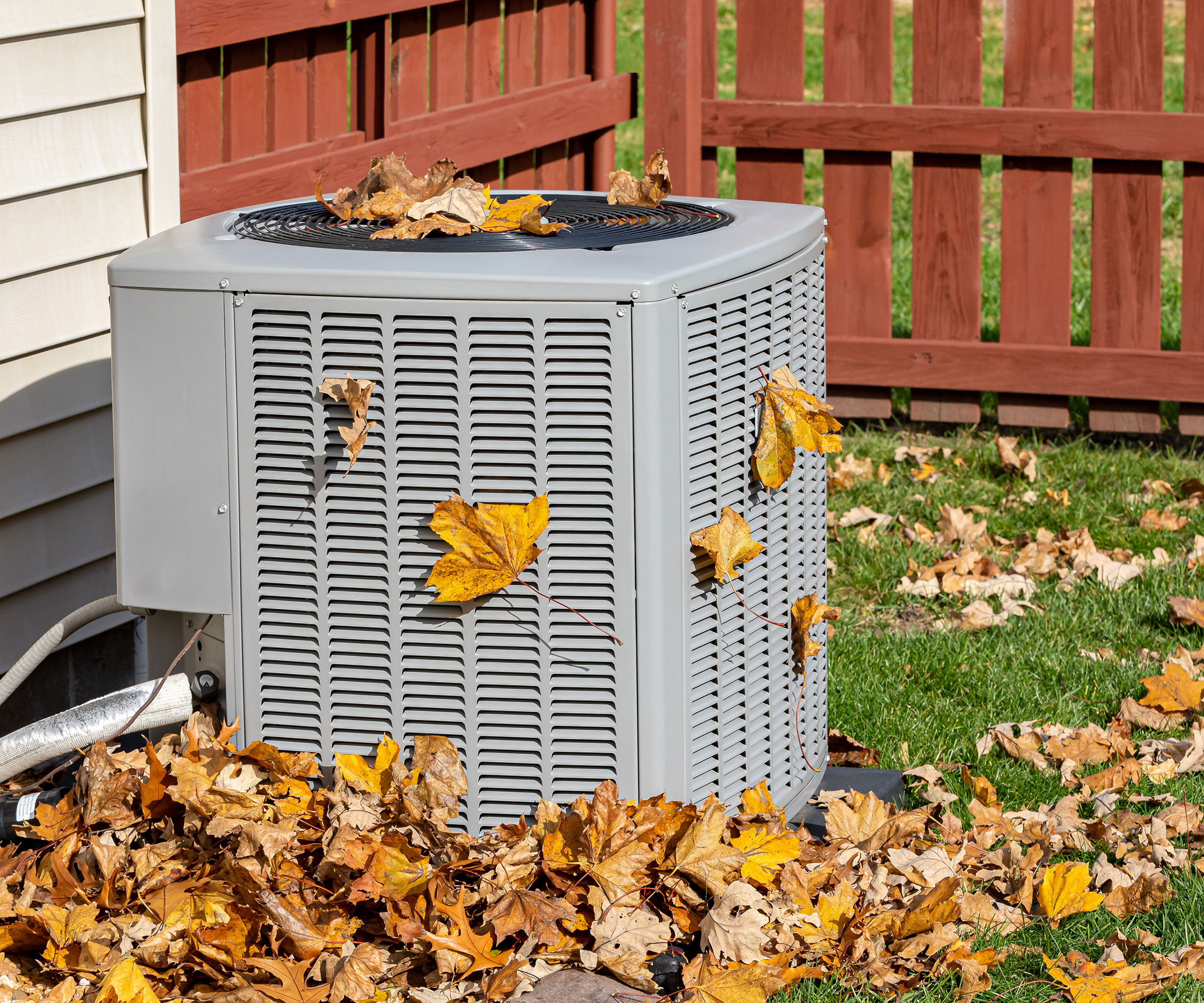 air source heat pump covered in leaves