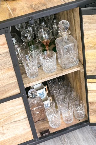Wooden storage cabinet filled with glassware