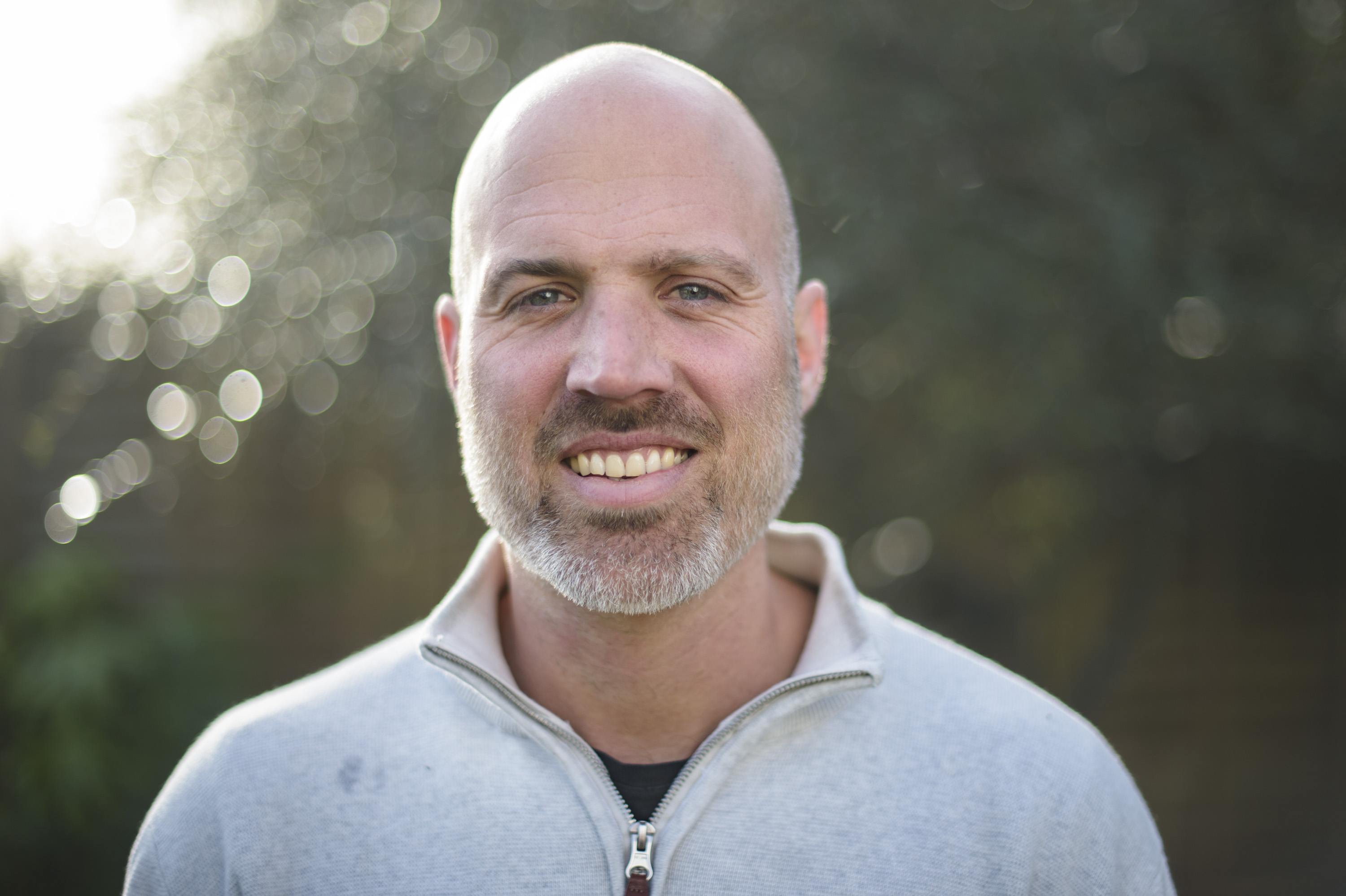 Portrait of man with dappled light through background tree