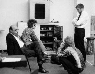 Ahmet Ertegun, guitarist Eric Clapton, producer Felix Pappalardi, drummer Ginger Baker and engineer Tom Dowd of the rock band "Cream" converse while recording at the "Strange Brew" recording session at Atlantic Recording Studios on April 5, 1967 in New York City, New York.