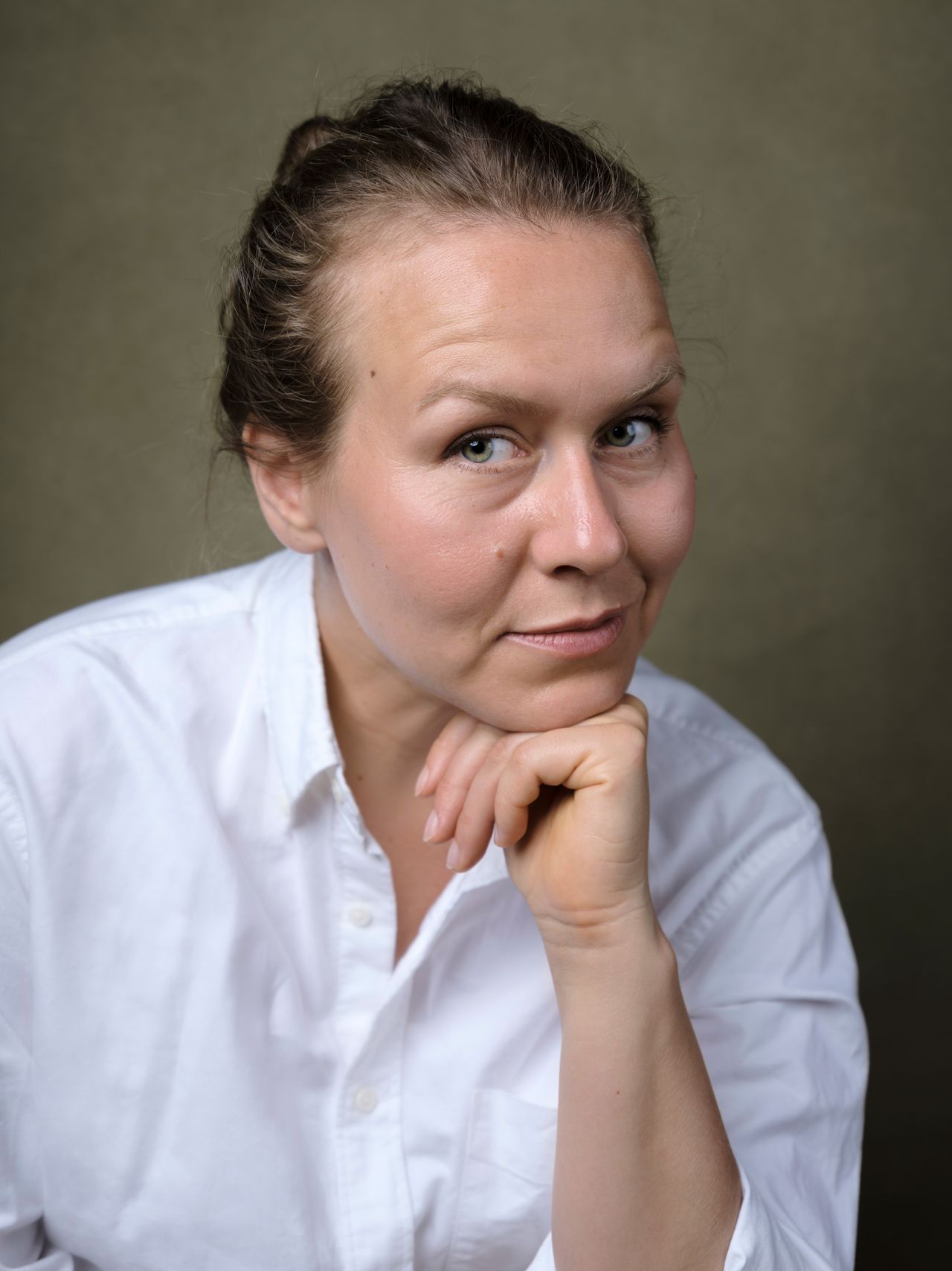 A portrait of a woman on a green backdrop taken by portrait photographer Kalum Carter