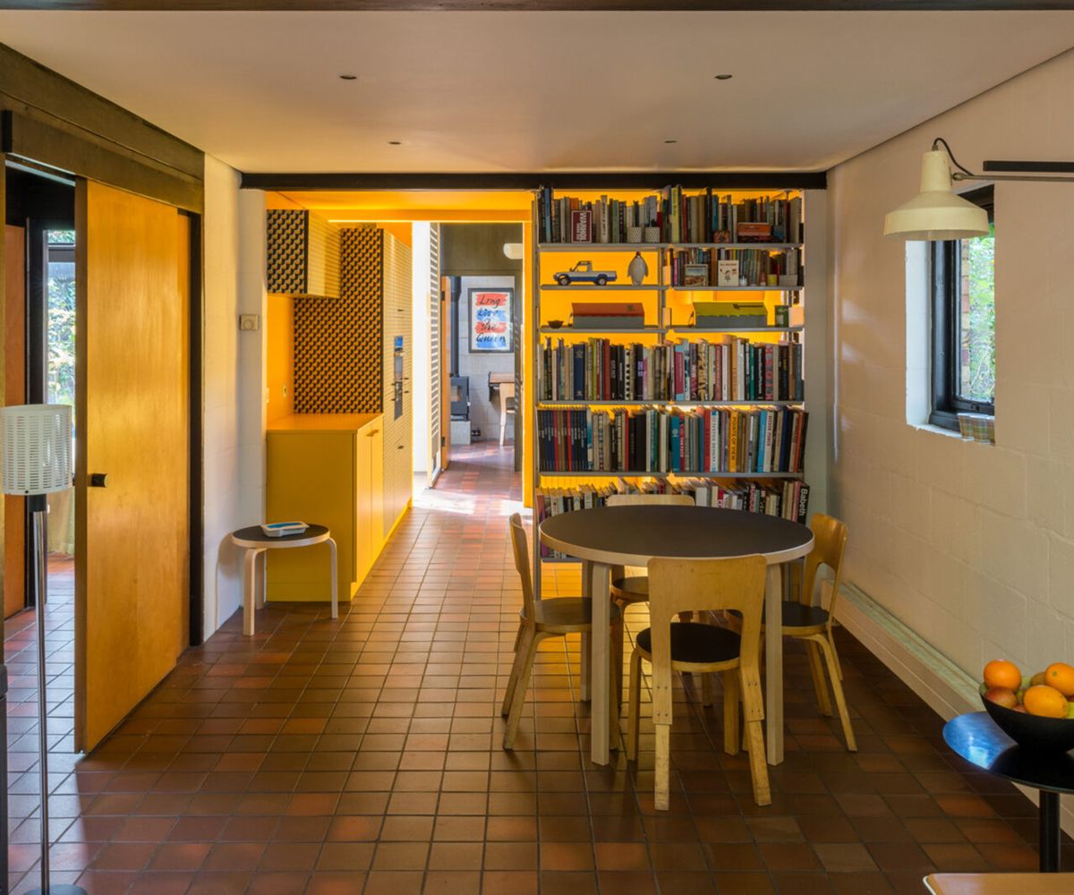 Before shots of 1 970s style single storey london house before a renovation and first floor extension. There is a lack of natural light but pops of bright yellow interiors a terracotta tiled floor and built in log burner
