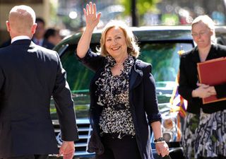 Hilary Clinton waves to photographers
