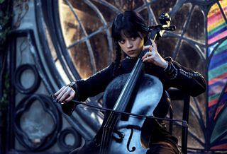 Jenna Ortega plays a cello in a spooky room as wednesday addams in a still from the netflix series wednesday